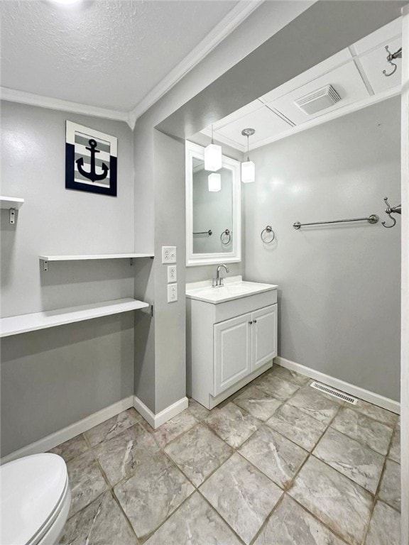 bathroom with a textured ceiling, vanity, toilet, and ornamental molding