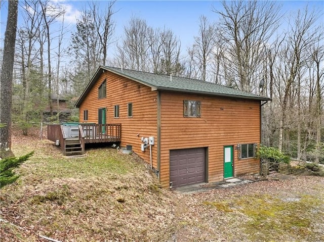 view of side of home featuring a garage and a wooden deck