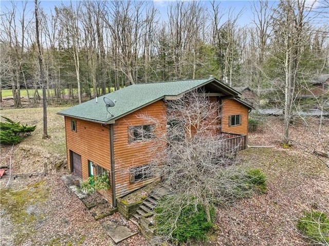 view of side of property with a wooden deck and a garage