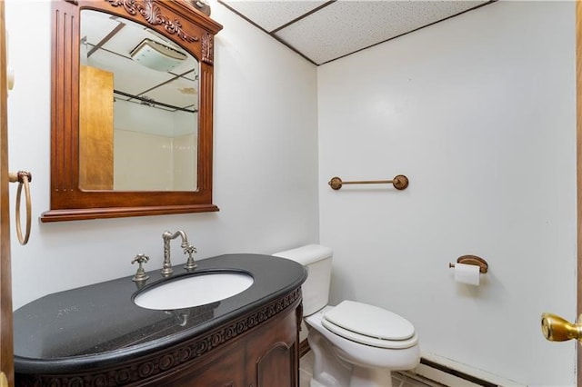 bathroom featuring a paneled ceiling, vanity, toilet, and baseboard heating