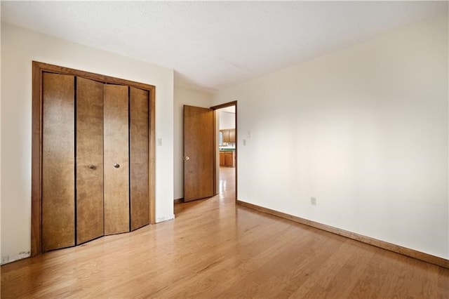 unfurnished bedroom featuring light hardwood / wood-style floors and a closet