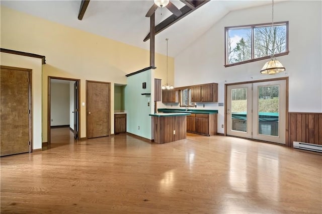 kitchen with pendant lighting, beam ceiling, light wood-type flooring, and high vaulted ceiling