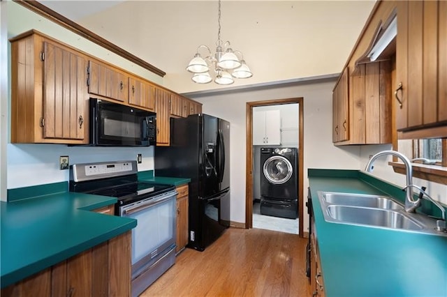 kitchen featuring black appliances, sink, a notable chandelier, light hardwood / wood-style floors, and washer / clothes dryer