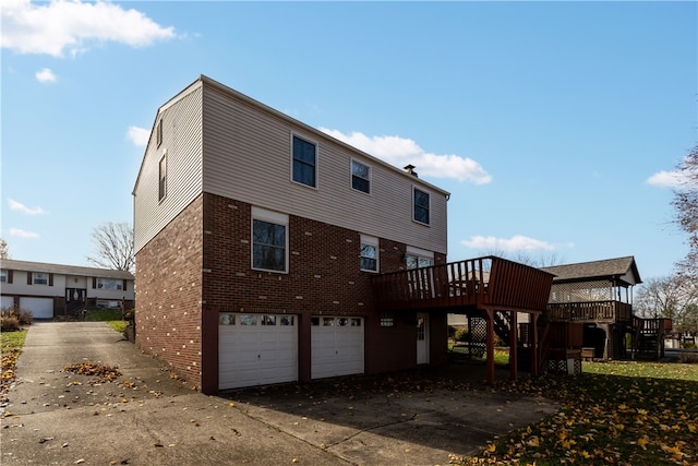 back of property with a wooden deck and a garage