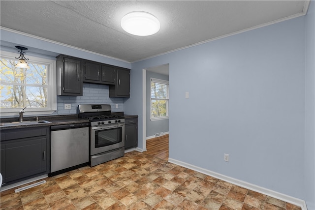 kitchen with sink, crown molding, decorative backsplash, a textured ceiling, and stainless steel appliances