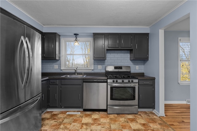 kitchen featuring a textured ceiling, stainless steel appliances, crown molding, and sink