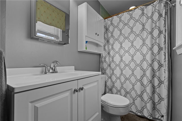 bathroom featuring a shower with shower curtain, vanity, and toilet