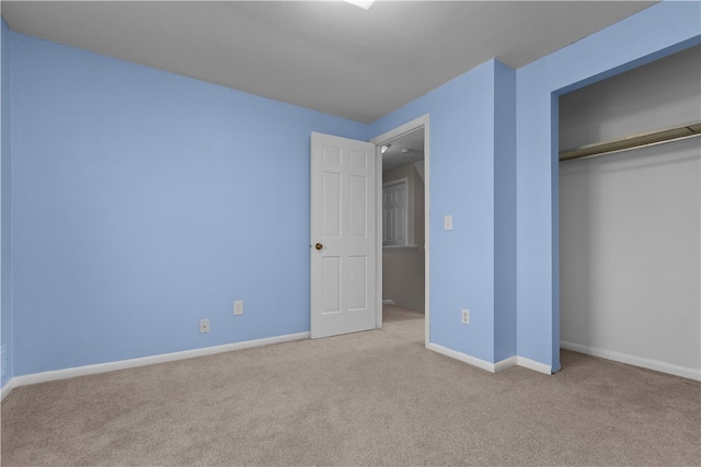 unfurnished bedroom featuring light colored carpet and a closet