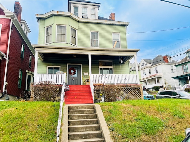 view of front of home with covered porch and a front yard