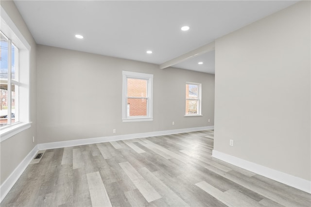 spare room with a wealth of natural light and light hardwood / wood-style flooring