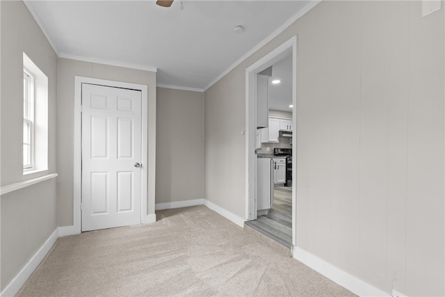 unfurnished bedroom featuring crown molding, ceiling fan, and light colored carpet