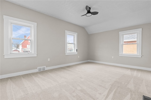 unfurnished room featuring carpet floors, vaulted ceiling, and ceiling fan