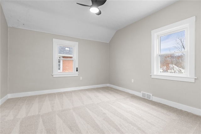 carpeted spare room featuring ceiling fan and lofted ceiling