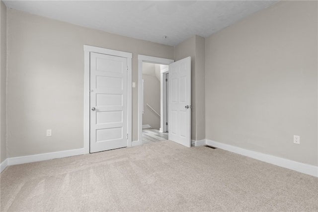 unfurnished bedroom featuring light carpet