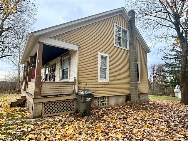 view of side of property featuring covered porch