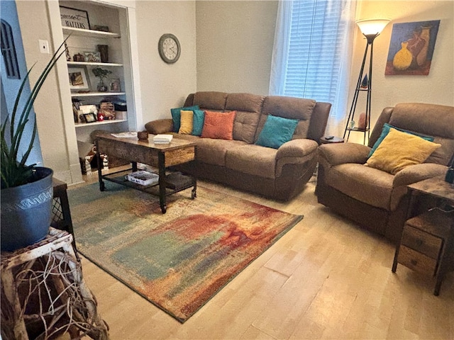 living room featuring hardwood / wood-style floors and built in shelves