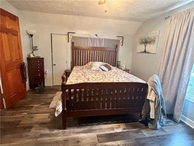 bedroom with dark hardwood / wood-style floors, ceiling fan, a textured ceiling, and vaulted ceiling