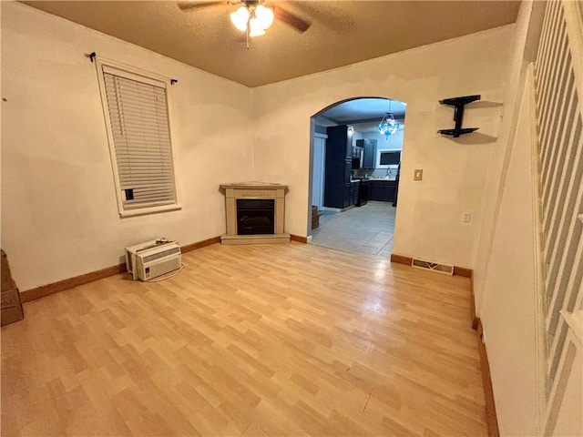 1713 W 8th St, Patterson Twp, PA 15010 - unfurnished living room featuring ceiling fan, wood finished floors, arched walkways, and a fireplace with raised hearth