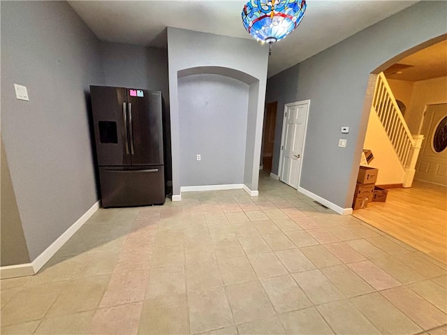 1713 W 8th St, Patterson Twp, PA 15010 - spare room featuring arched walkways, stairway, light tile patterned flooring, and baseboards