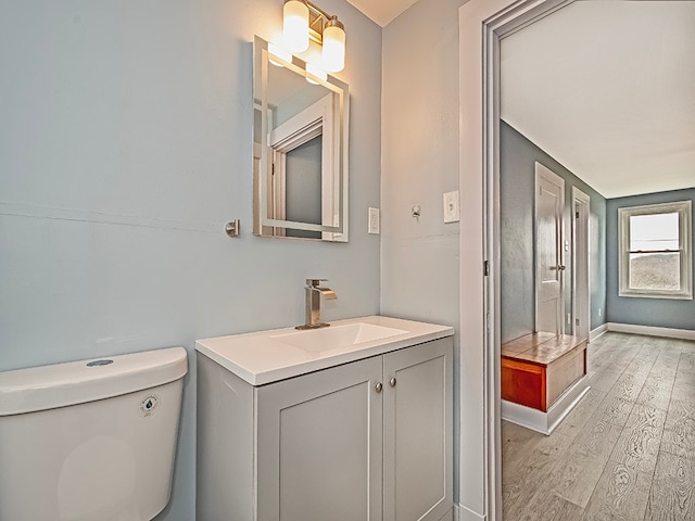 bathroom featuring wood-type flooring, vanity, and toilet