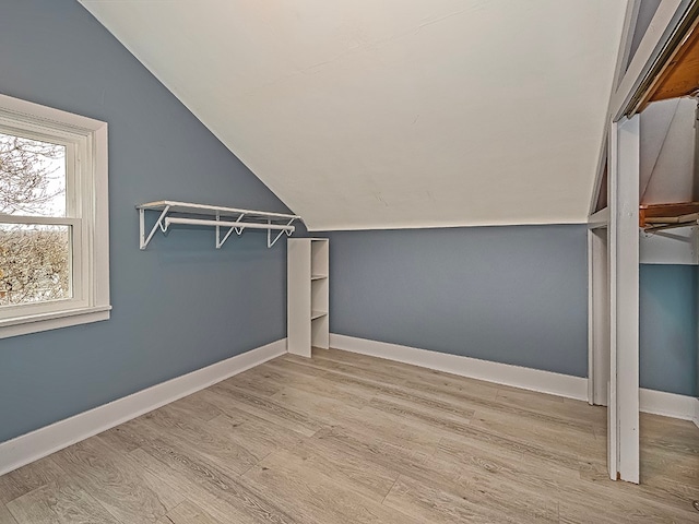 spacious closet featuring light hardwood / wood-style flooring and lofted ceiling