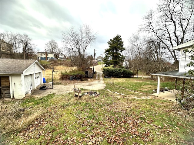 view of yard featuring a trampoline, a garage, and an outdoor structure