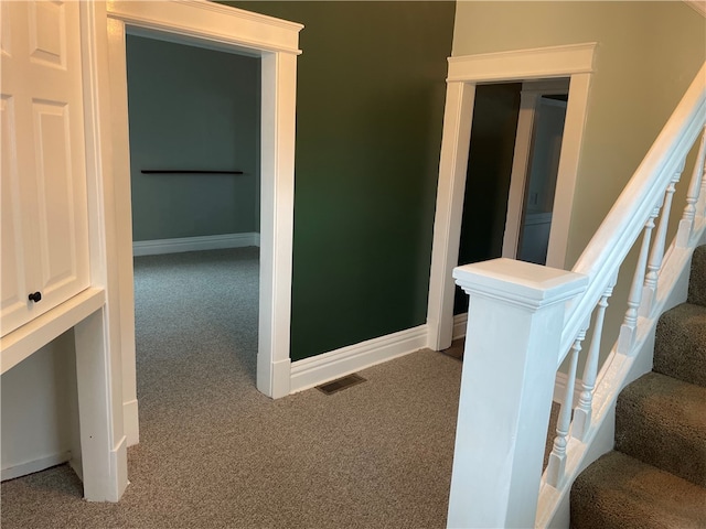 hallway with dark colored carpet