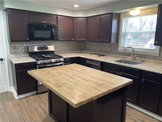 kitchen featuring a kitchen island, light wood-type flooring, sink, and stainless steel gas range