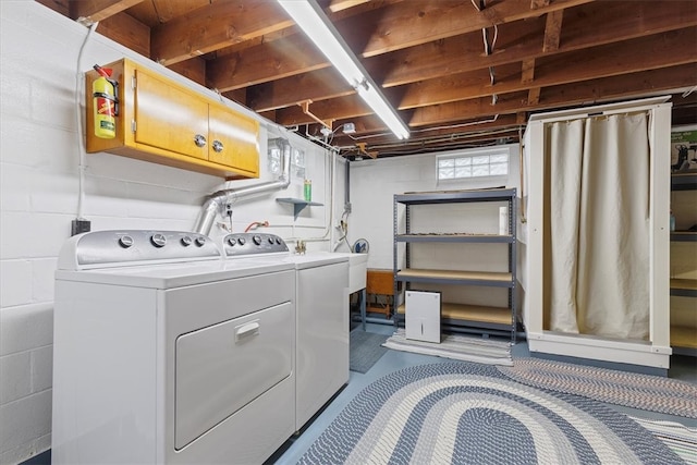 clothes washing area with cabinets and washing machine and dryer