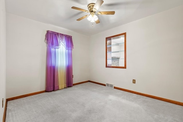 carpeted spare room featuring ceiling fan