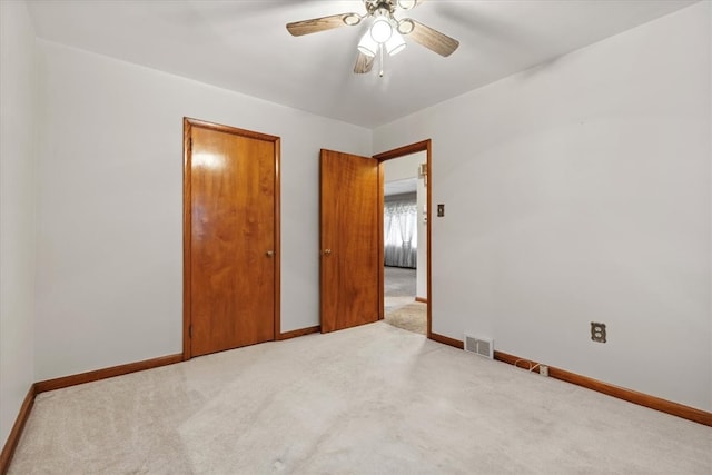 unfurnished bedroom featuring light carpet and ceiling fan