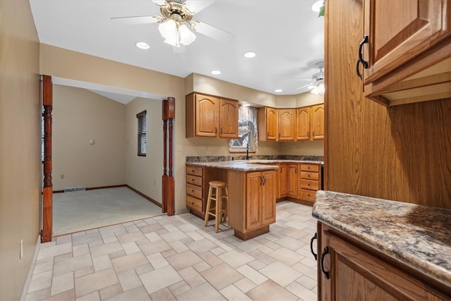 kitchen with ceiling fan and light colored carpet