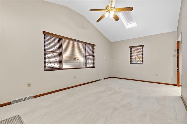 carpeted spare room with lofted ceiling with skylight and ceiling fan