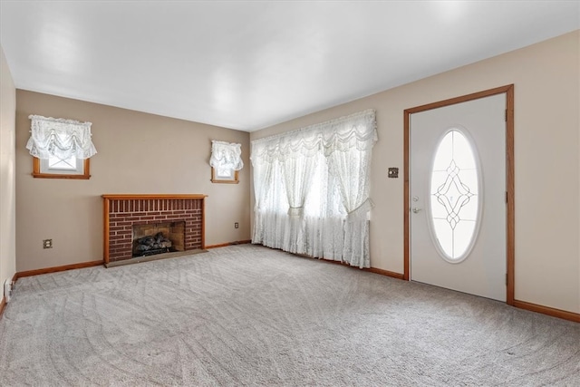 foyer with light colored carpet and a fireplace