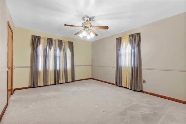 carpeted spare room featuring ceiling fan