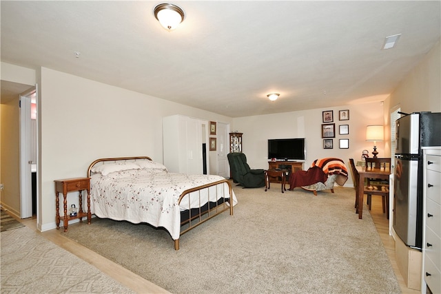 carpeted bedroom with stainless steel fridge