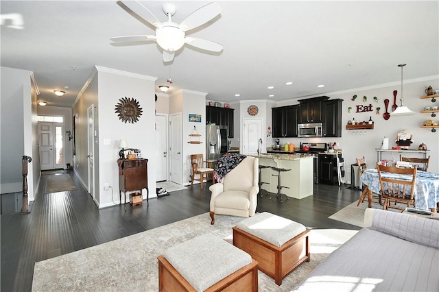 living room with ceiling fan, dark hardwood / wood-style flooring, ornamental molding, and sink