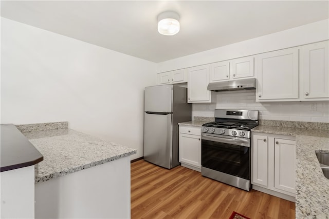 kitchen with white cabinets, light hardwood / wood-style floors, and stainless steel appliances