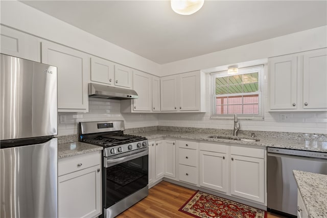 kitchen with stainless steel appliances, white cabinetry, and sink