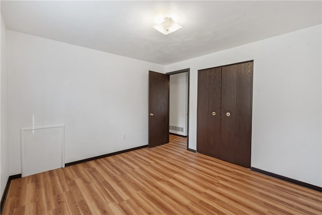 unfurnished bedroom featuring light hardwood / wood-style floors and a closet