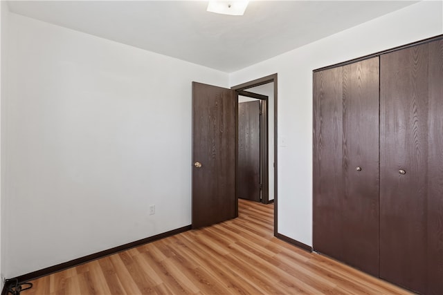 unfurnished bedroom featuring light wood-type flooring and a closet