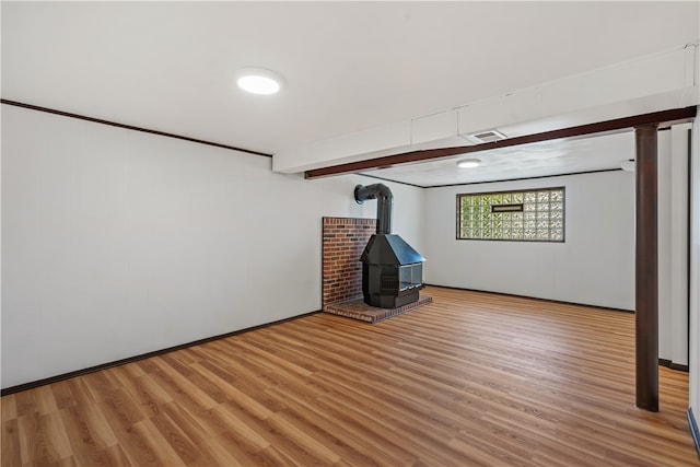 unfurnished living room with a wood stove and hardwood / wood-style floors