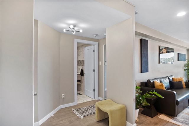 corridor featuring light hardwood / wood-style floors and a notable chandelier