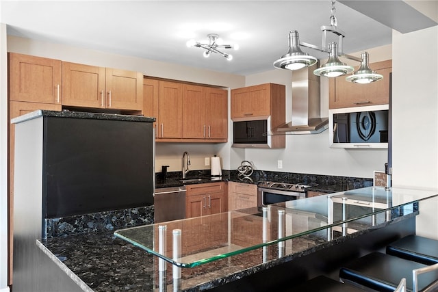 kitchen with island exhaust hood, dark stone counters, stainless steel appliances, sink, and pendant lighting