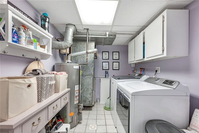 clothes washing area featuring cabinets, washing machine and dryer, light tile patterned floors, and gas water heater