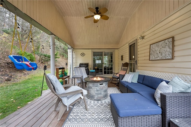 deck with ceiling fan and an outdoor living space with a fire pit