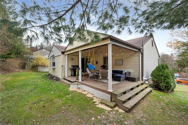 rear view of house with a lawn, an outdoor living space, and a wooden deck