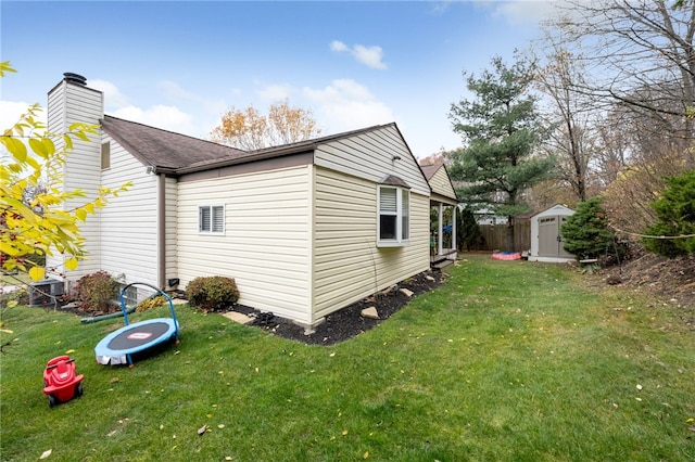 view of side of home featuring a storage unit and a yard