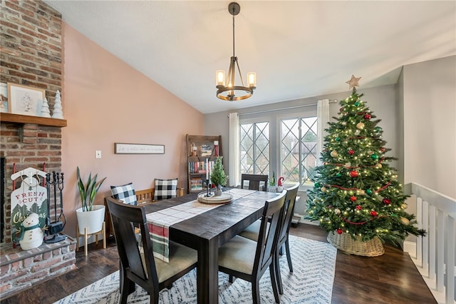 dining area featuring dark hardwood / wood-style floors, lofted ceiling, and a notable chandelier