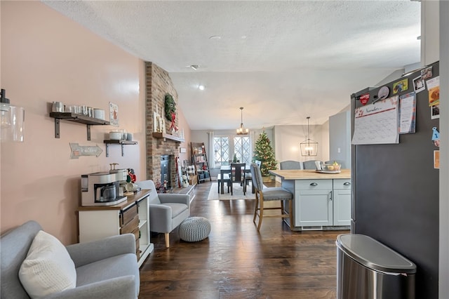 living room featuring dark hardwood / wood-style floors, lofted ceiling, and a textured ceiling